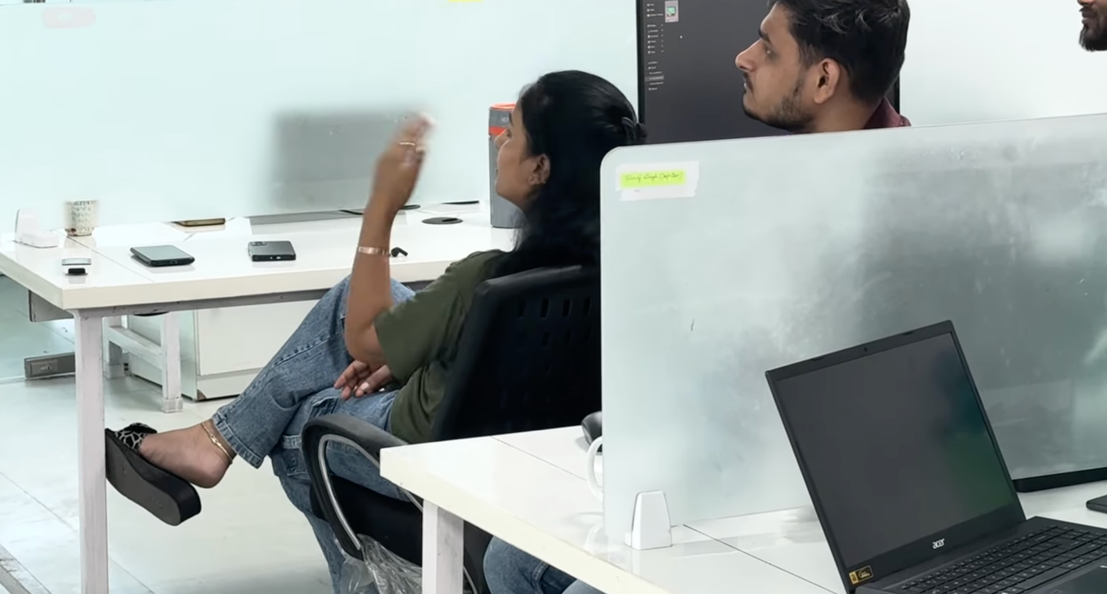 Female professional office chair पर बैठी हाथ उठाकर question पूछ रही है — Kabeer Goswami corporate session के दौरान। Engaged dialogue।