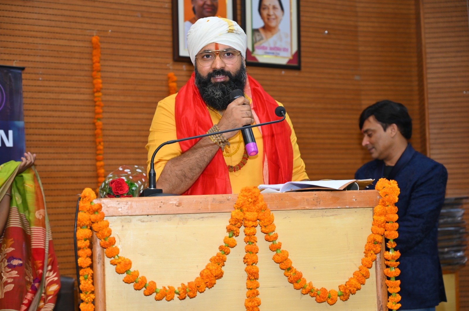 Kabeer Ji Maharaj गेंदे के फूलों से सजे podium पर Daily Discourse देते हुए — Ownership और Infinite Possibilities पर प्रवचन