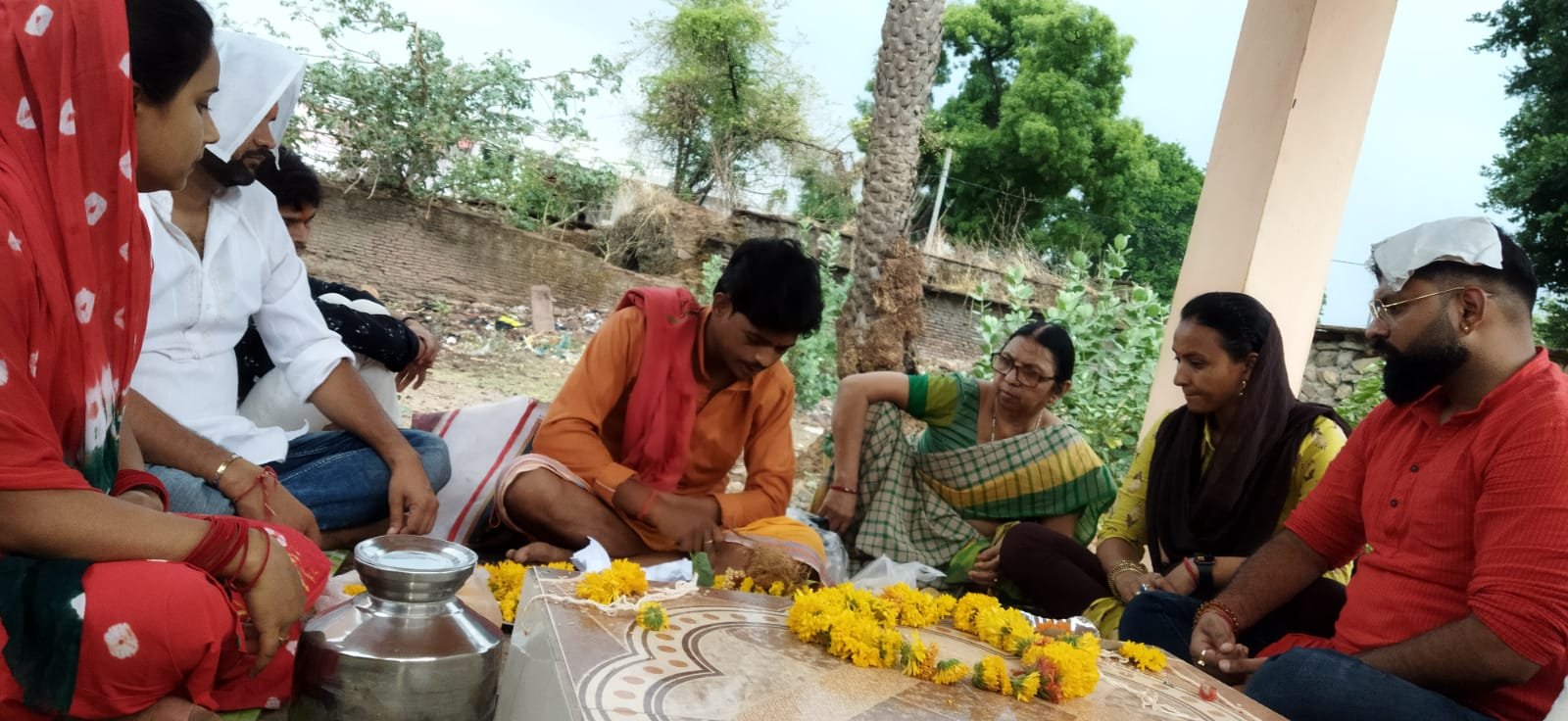 Kabeer Ji Maharaj का परिवार पितृ स्थान पर श्रद्धा से अर्घ्य देते हुए — श्राद्ध पूजा, मैरीगोल्ड पुष्प, जल अर्पण और कुटुंब सभी उपस्थित