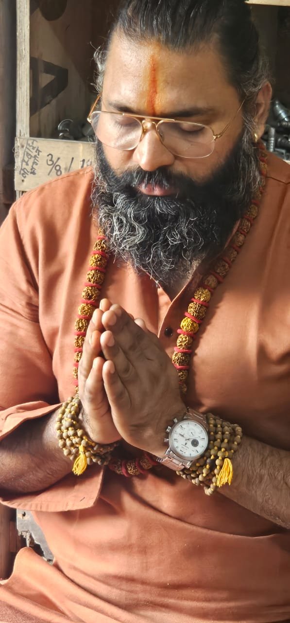 Kabeer Ji Maharaj (Kabeer Goswami) namaskar मुद्रा में — आंखें बंद, रुद्राक्ष माला, सोने का चश्मा, तिलक। Spiritual depth और grounded wisdom।